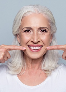 Older woman pointing to flawless smile
