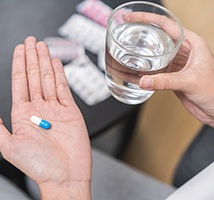 Holding glass of water and an antibiotic