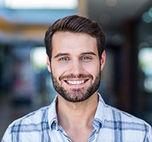 Woman sitting in dental chair smiling
Bearded man standing and smiling