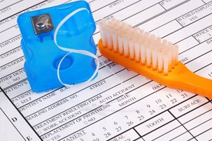 toothbrush and floss on dental insurance forms