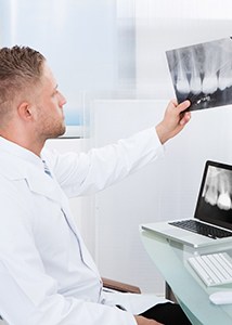 Implant dentist in Jonesboro holding an X-ray