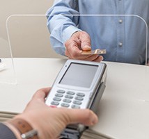 A male patient paying the cost of dental crowns
