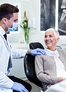 Woman in dental chair smiling at dentist