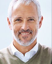 Male wearing a brown sweater with white collard shirt