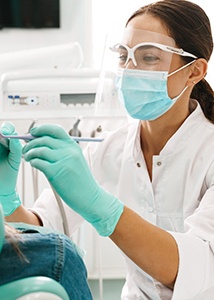 a dentist inspecting her patient’s smile