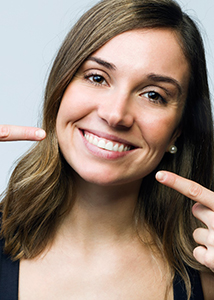 Woman pointing to her smile