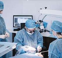 Implant dentist in Jonesboro performing oral surgery alongside dental assistants