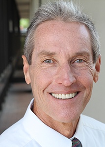 Man smiling outside an office