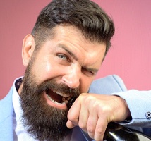 bearded man opening a bottle with his teeth