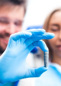 Implant dentist in Jonesboro holding implant post for a patient