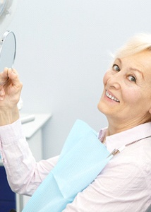 Woman with implant dentures in Jonesboro smiling in dental chair