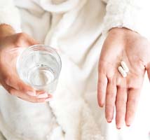 Patient holding pain medication after dental implant surgery in Jonesboro