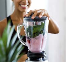 Woman making smoothies for recovering from dental implant surgery in Jonesboro