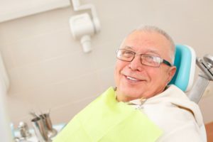 man smiling sitting in dentist chair