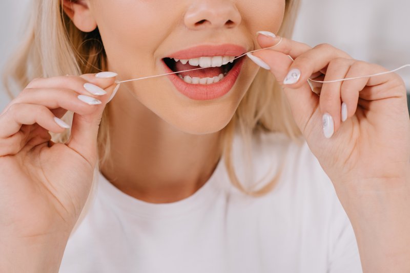 Woman flossing her teeth