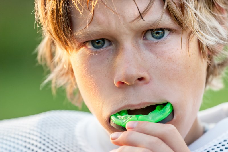 A child putting in his mouthguard for sports
