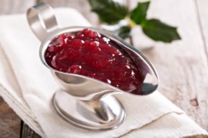 a gravy boat with cranberry sauce in it